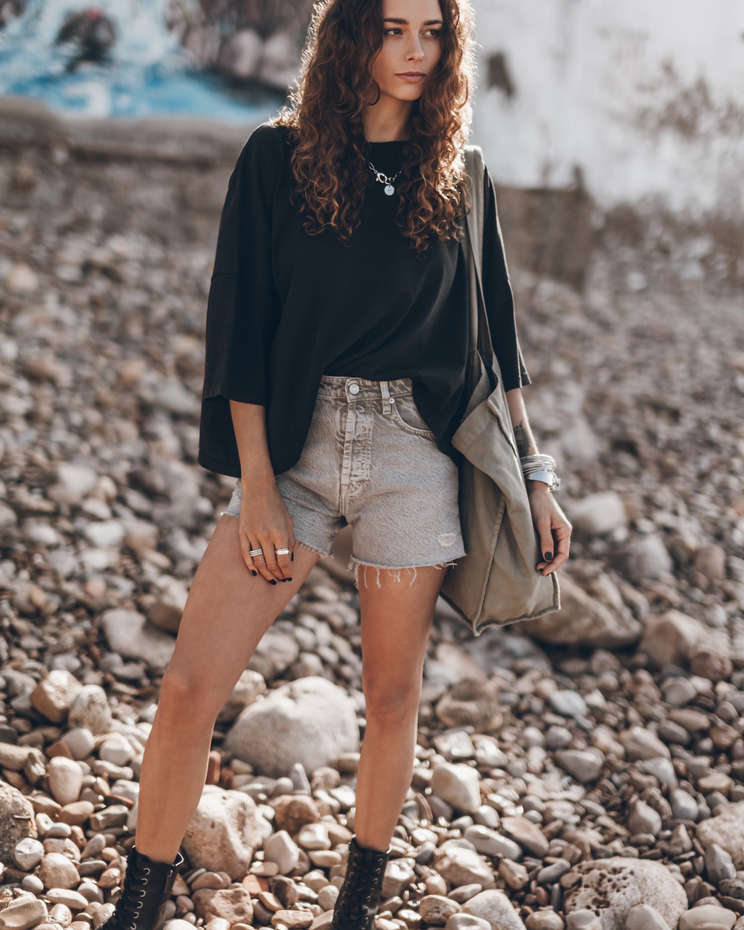 Khaki Faded Denim Shorts Dark Loose Cotton Shirt Black Laced Leather Boots Khaki Large Canvas Bag...