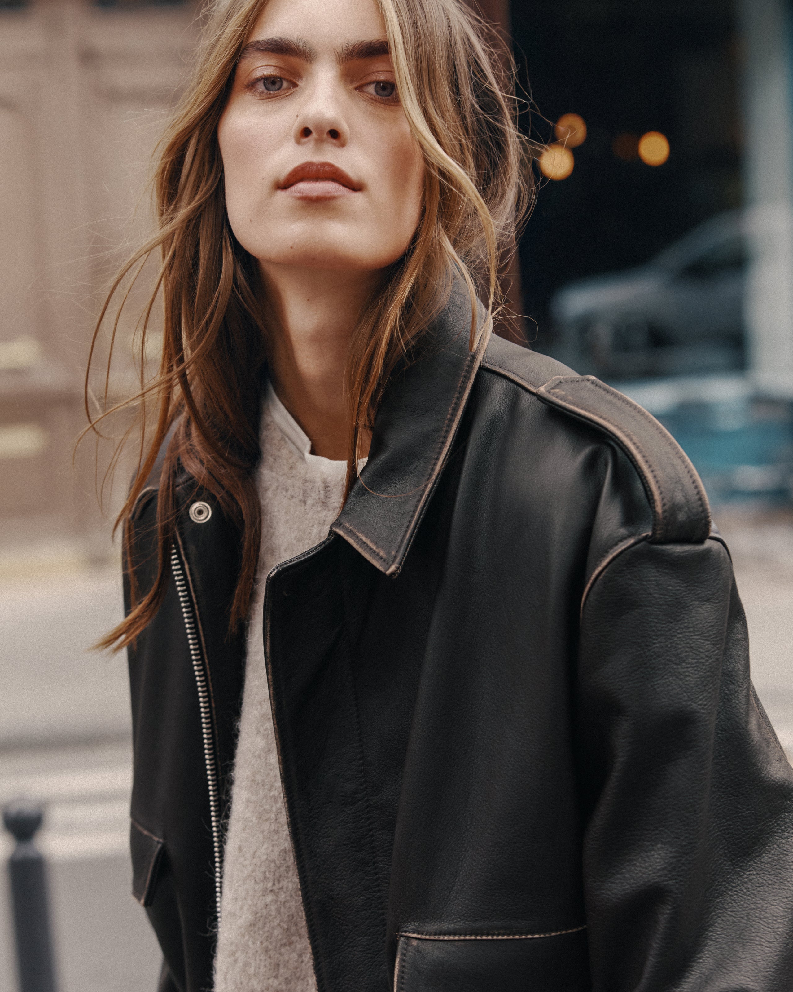 Person wearing a black leather jacket on a city street