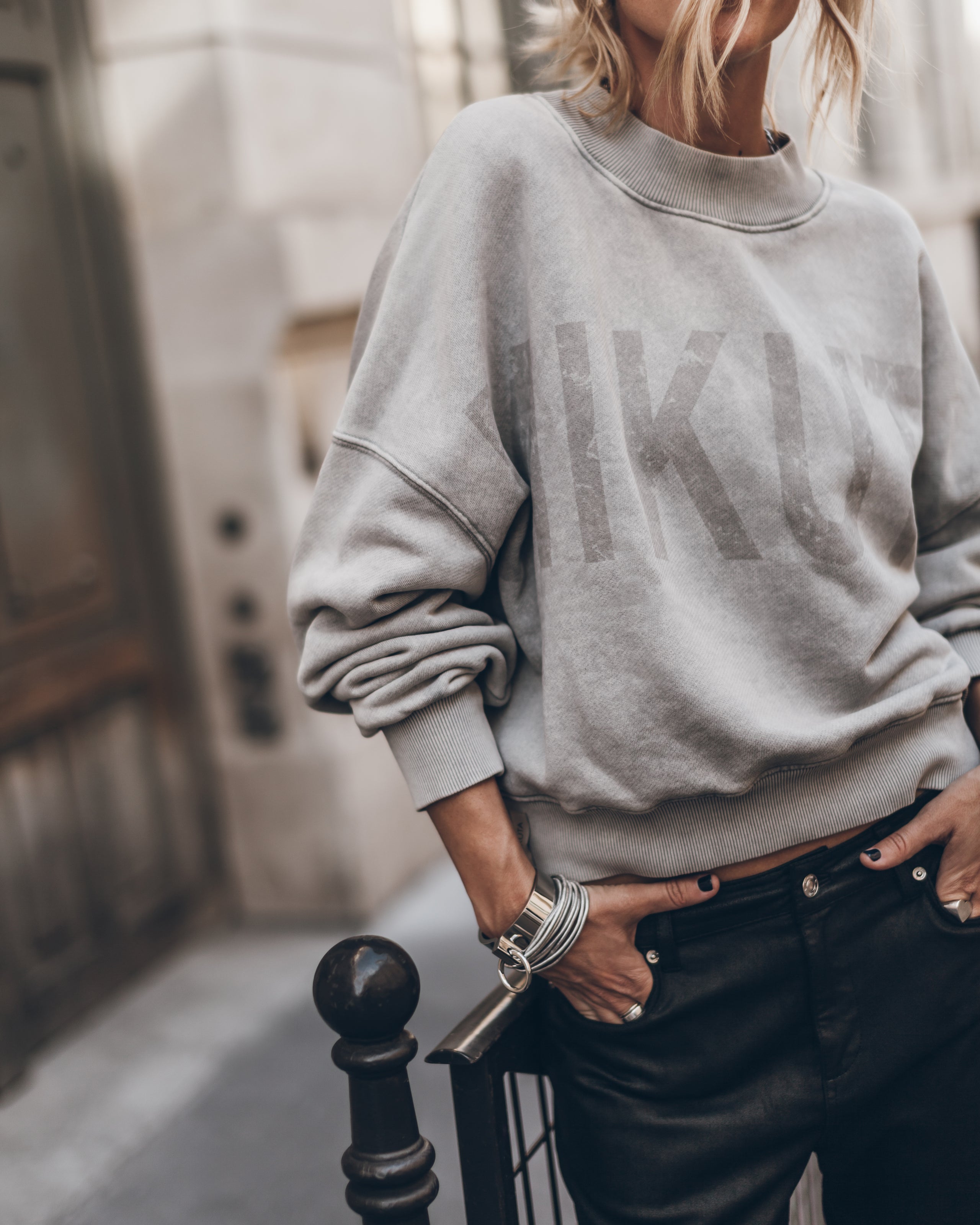 Light oversized sweater styled with black leather pants - casual chic