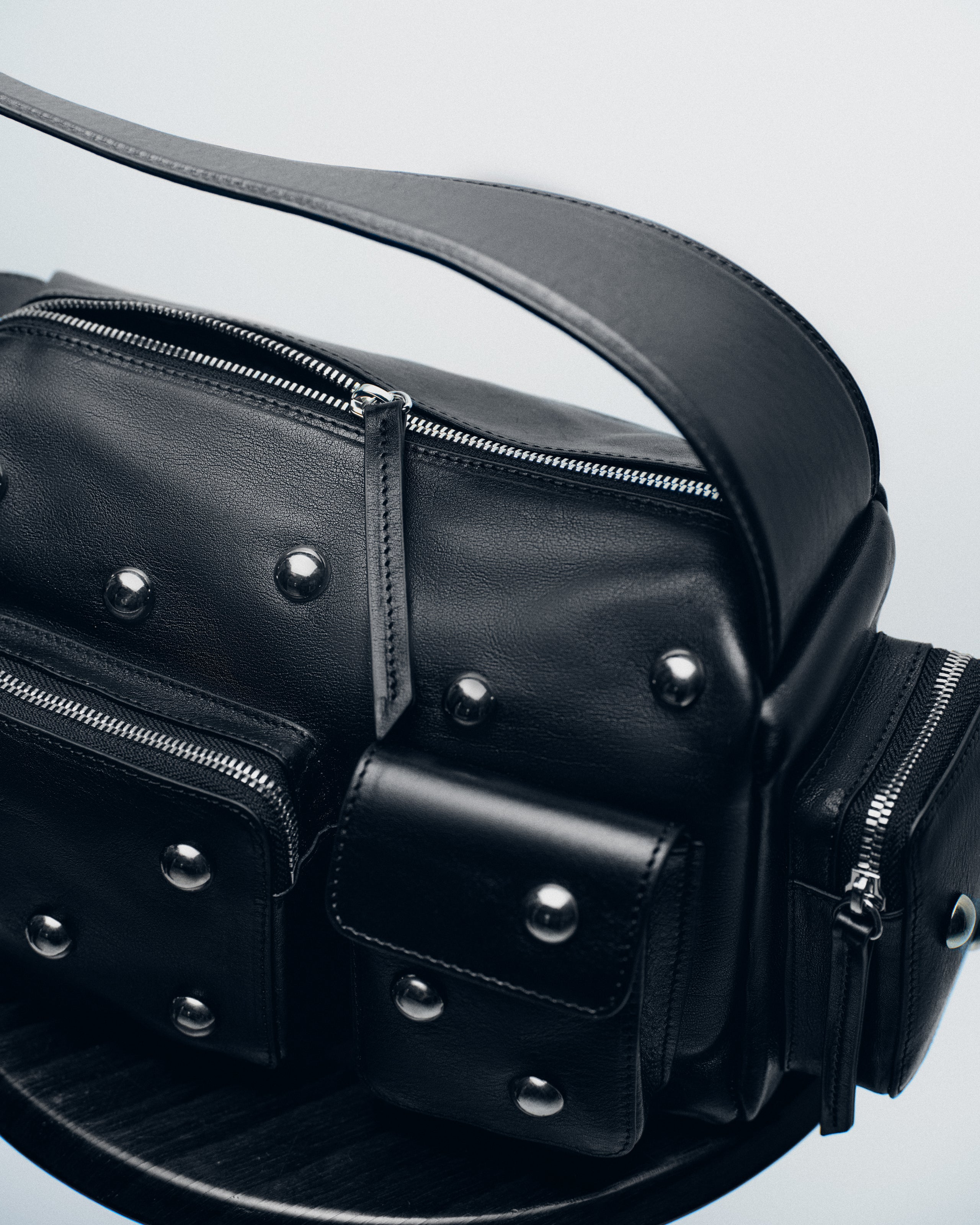 Black leather bag with silver studs and zippers.
