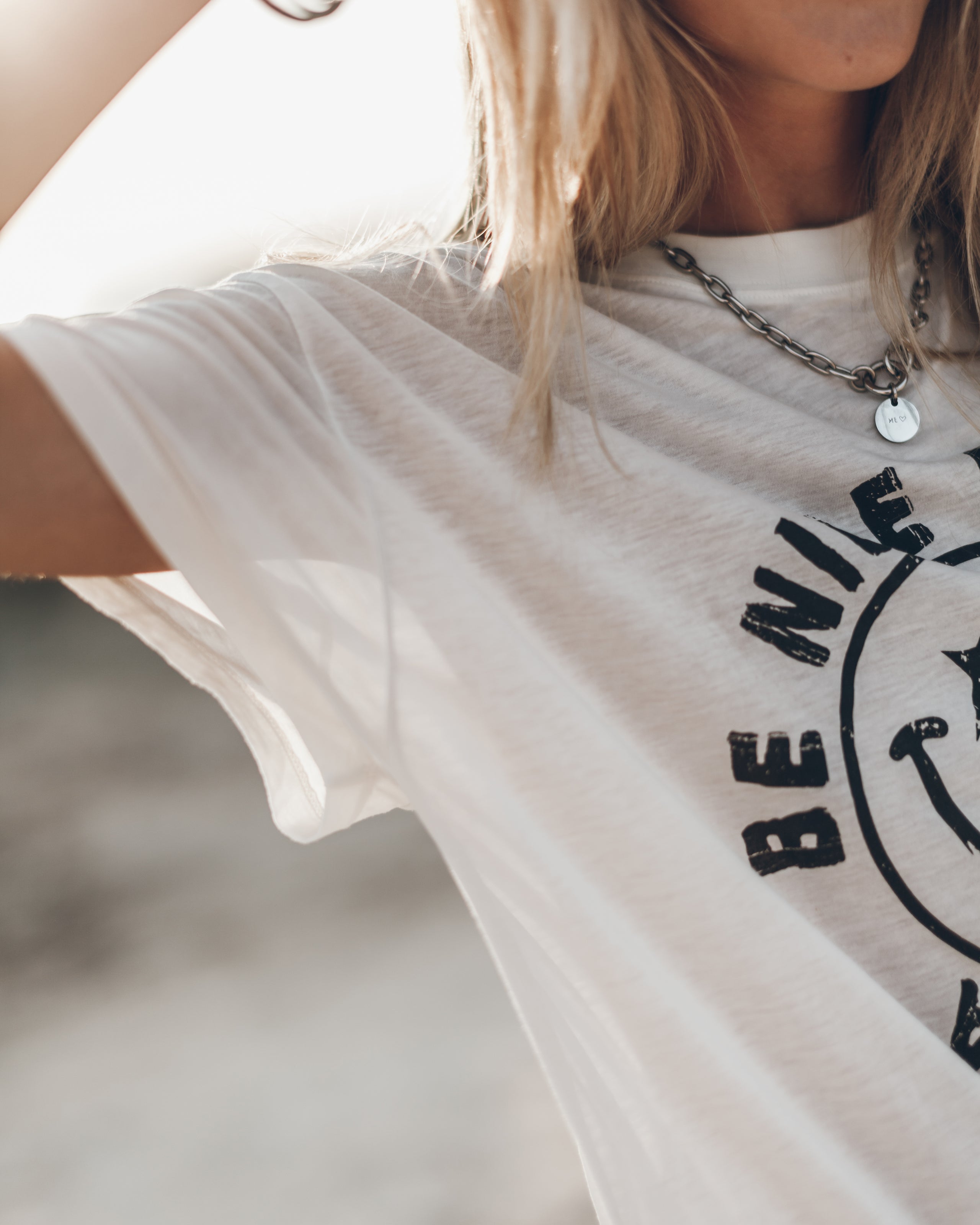 White short-sleeve T-shirt with black smiley face and "Be Nice" text on front.