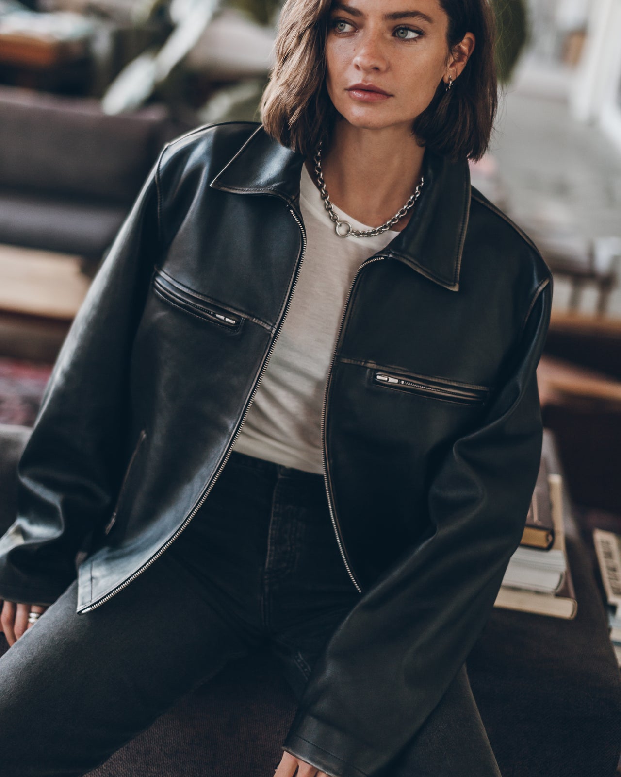 Person wearing a black leather jacket in an indoor setting