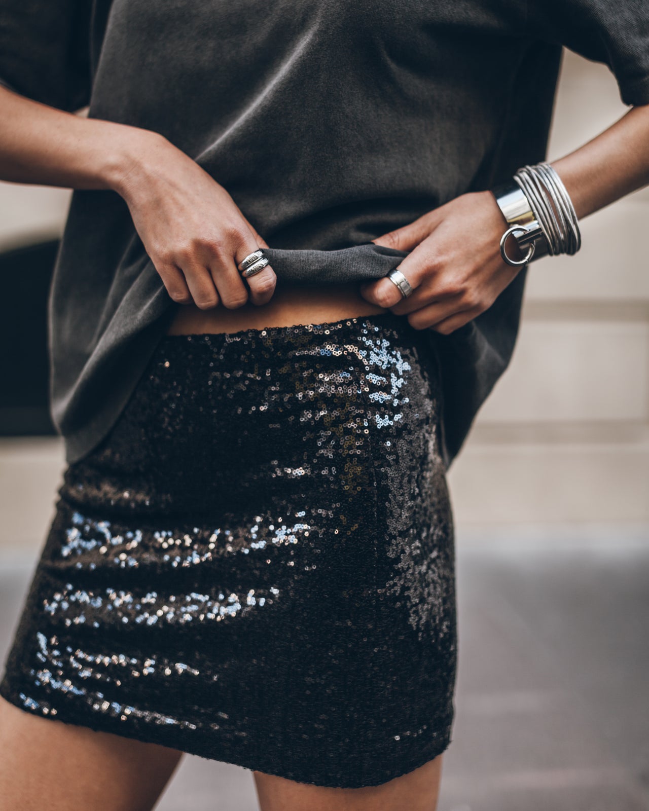 Person wearing a black sequin skirt with a blurred background