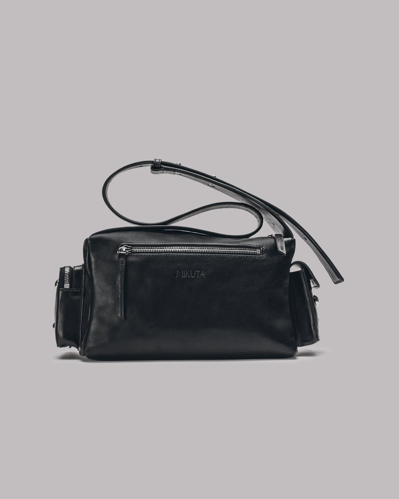 Black handbag with a strap on a gray background