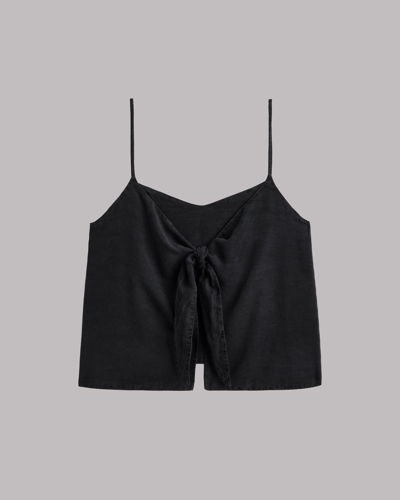 Black spaghetti strap top  with a knot detail on a gray background