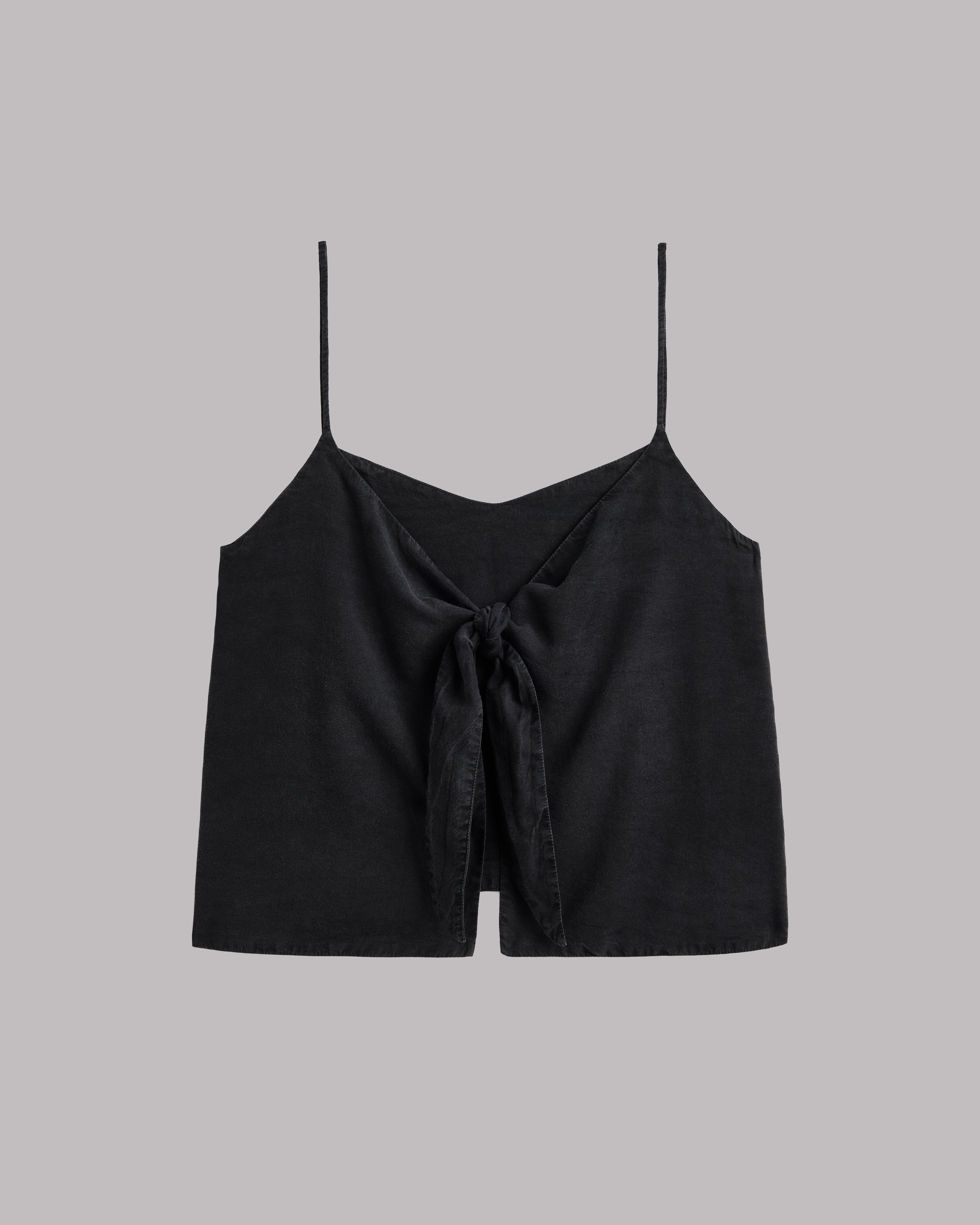 Black spaghetti strap top  with a knot detail on a gray background