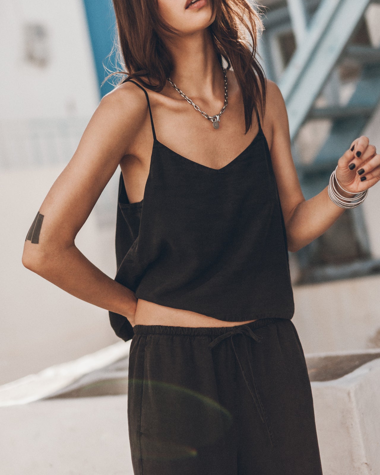 Woman wearing a black top and pants outdoors.