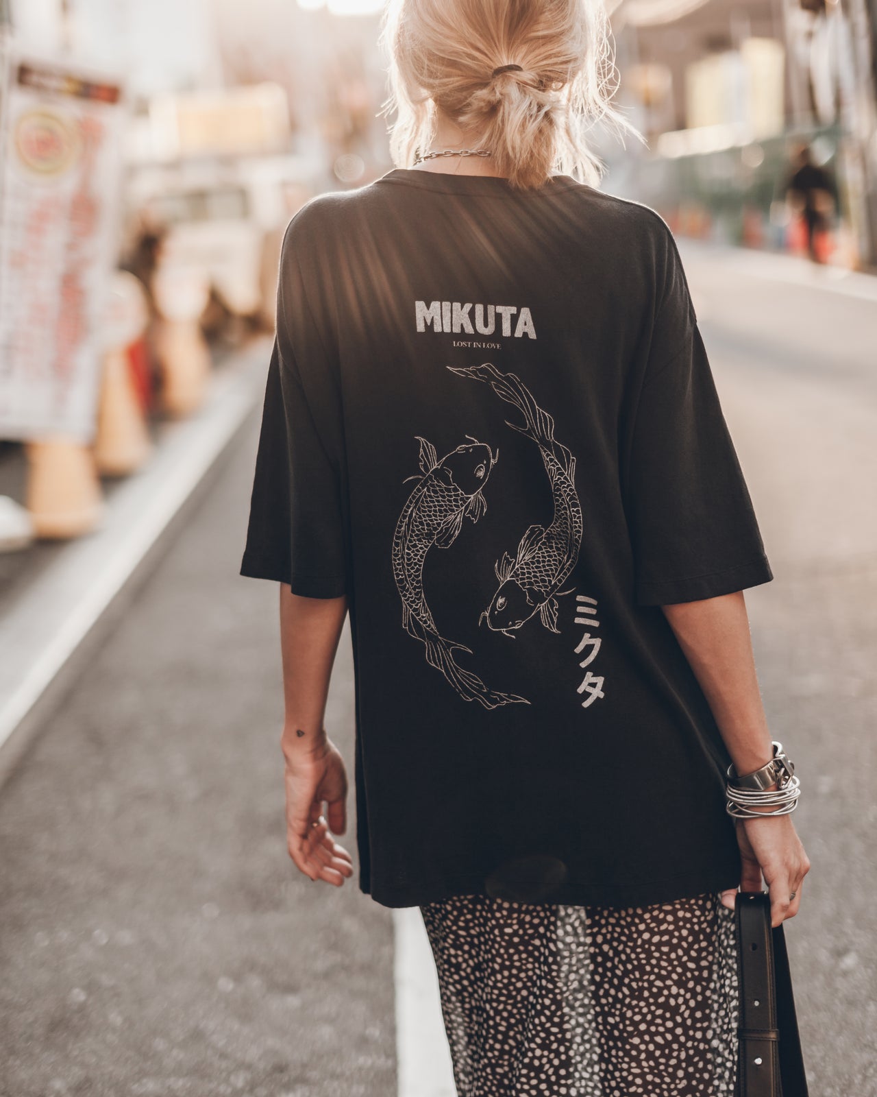 Person wearing a black t-shirt with 'MIKUTA' branding and koi fish design.
