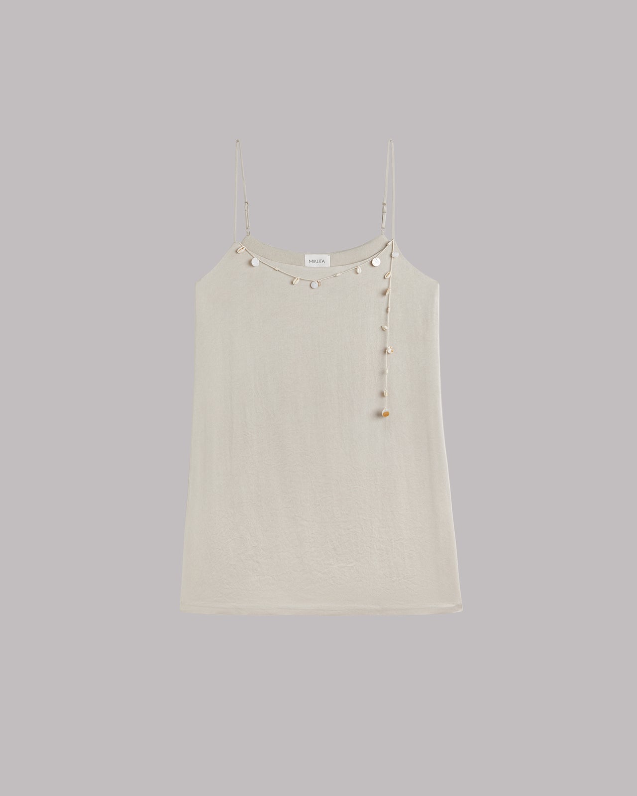 Beige dress with shell details on a gray background
