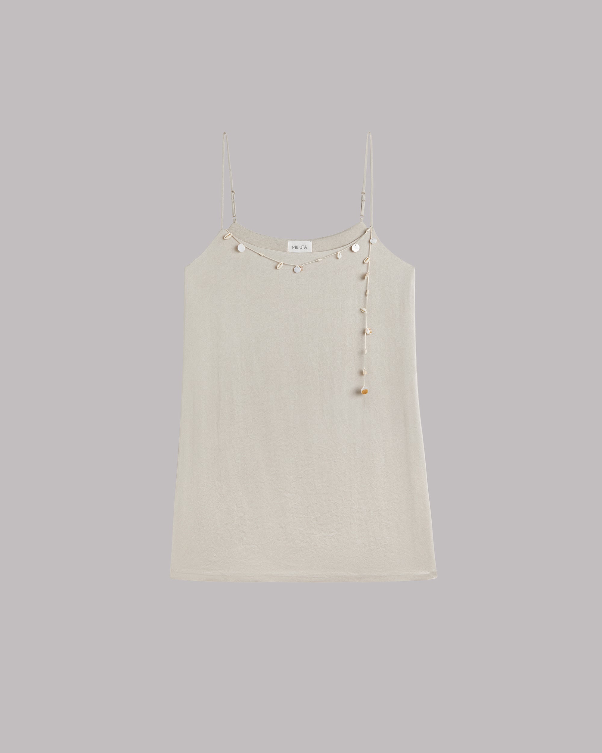 Beige dress with shell details on a gray background