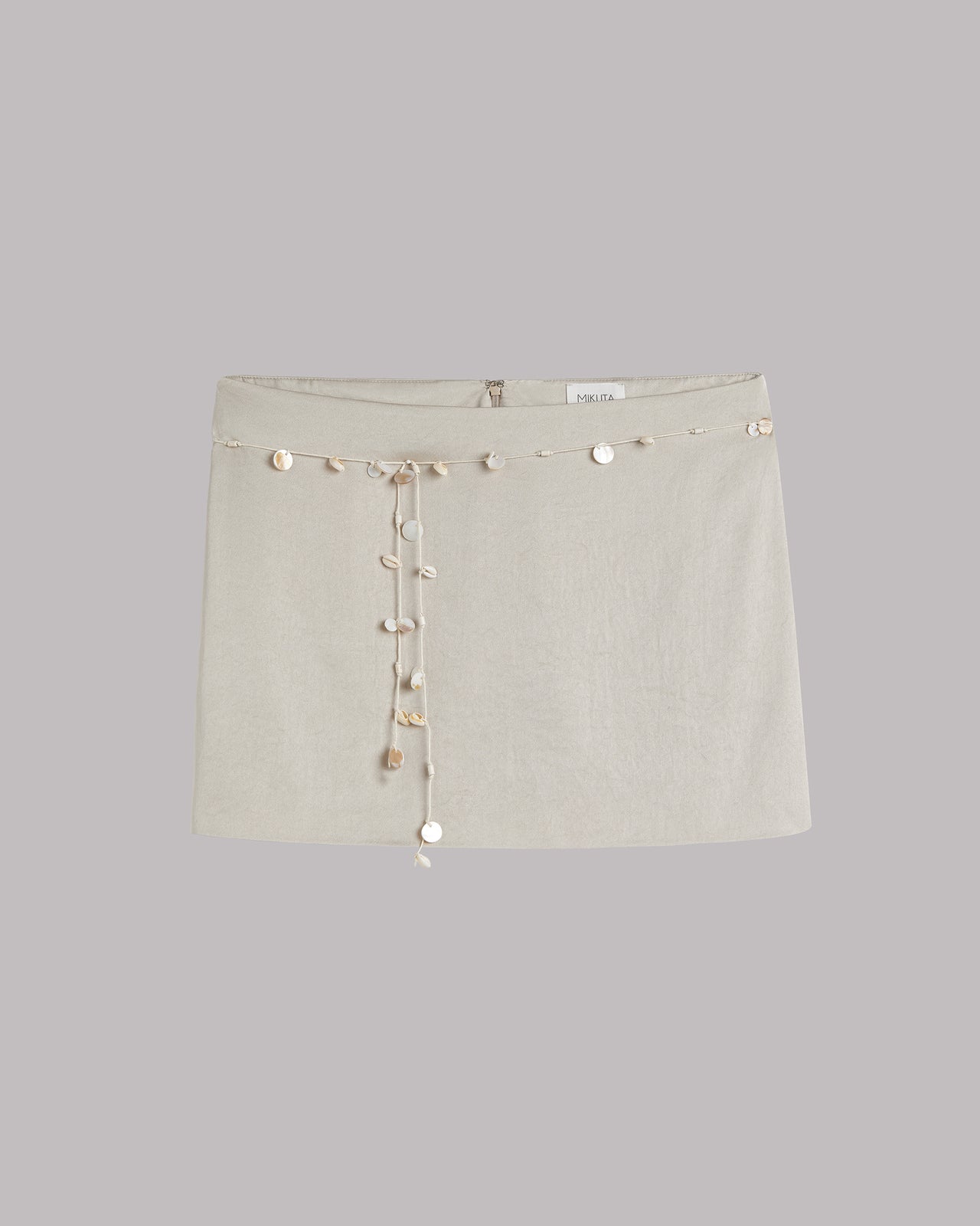 Light mini skirt with decorative shells on a light gray background