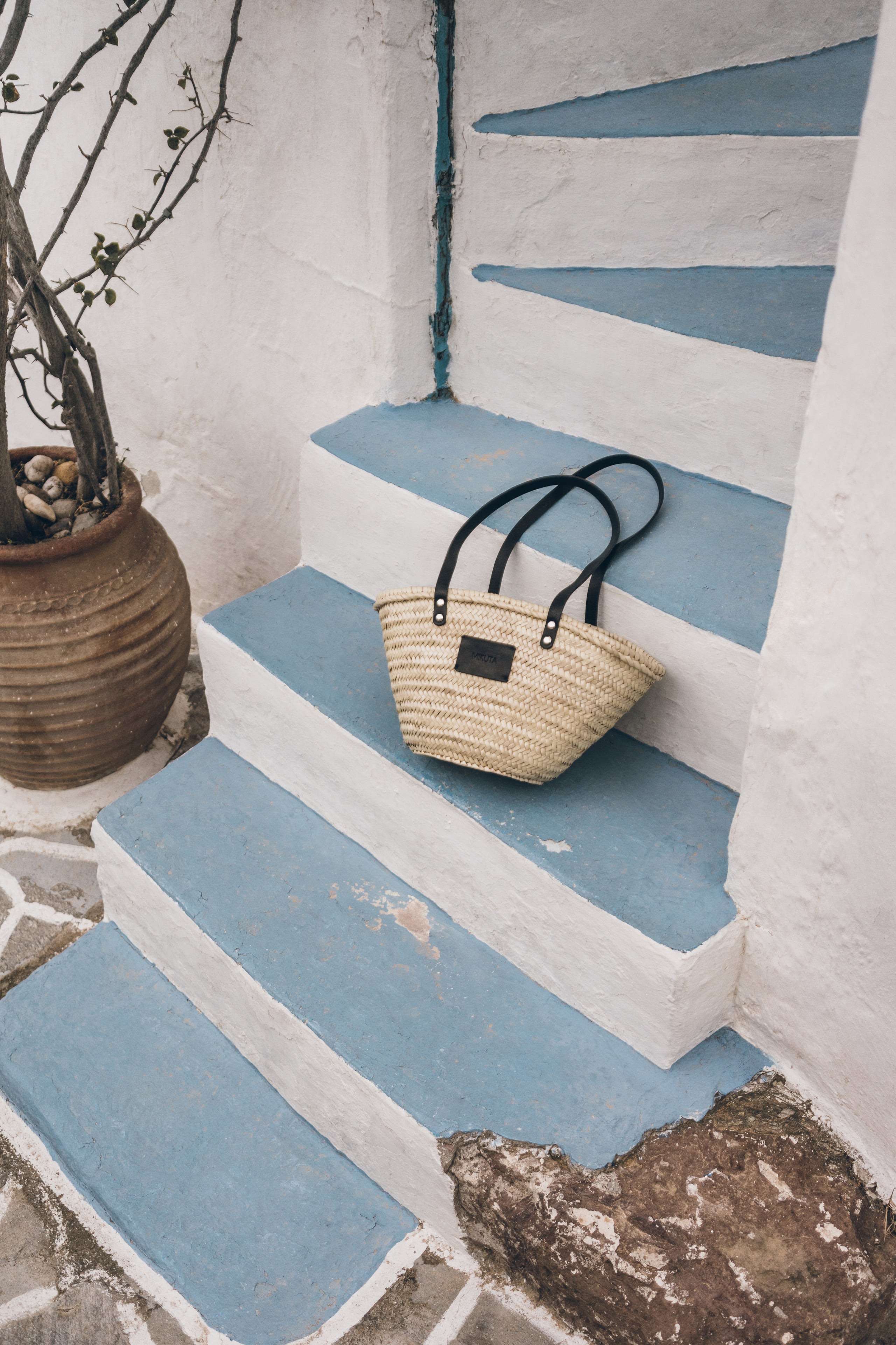 Woven bag on a blue and white striped staircase