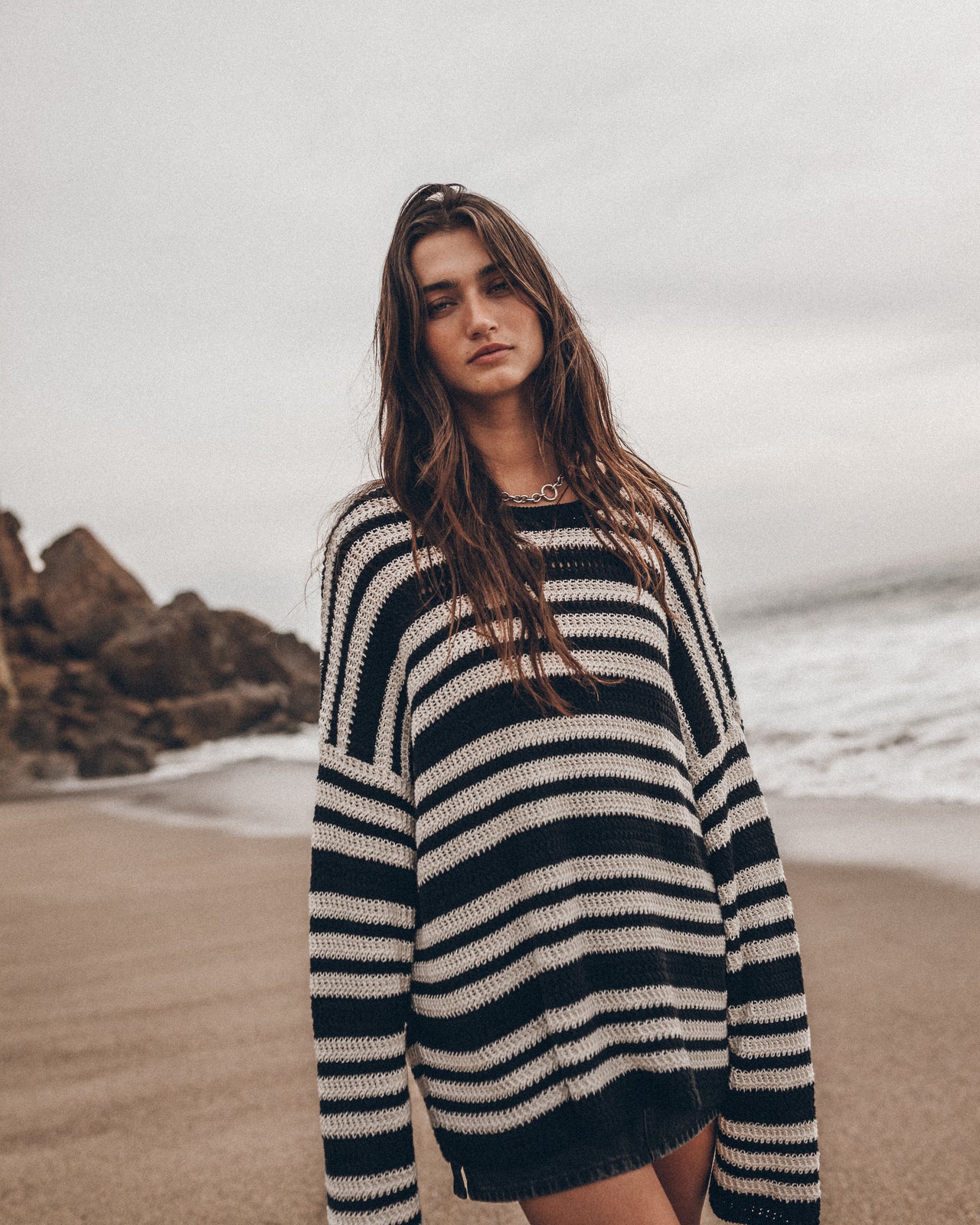 Woman wearing a striped sweater on a beach