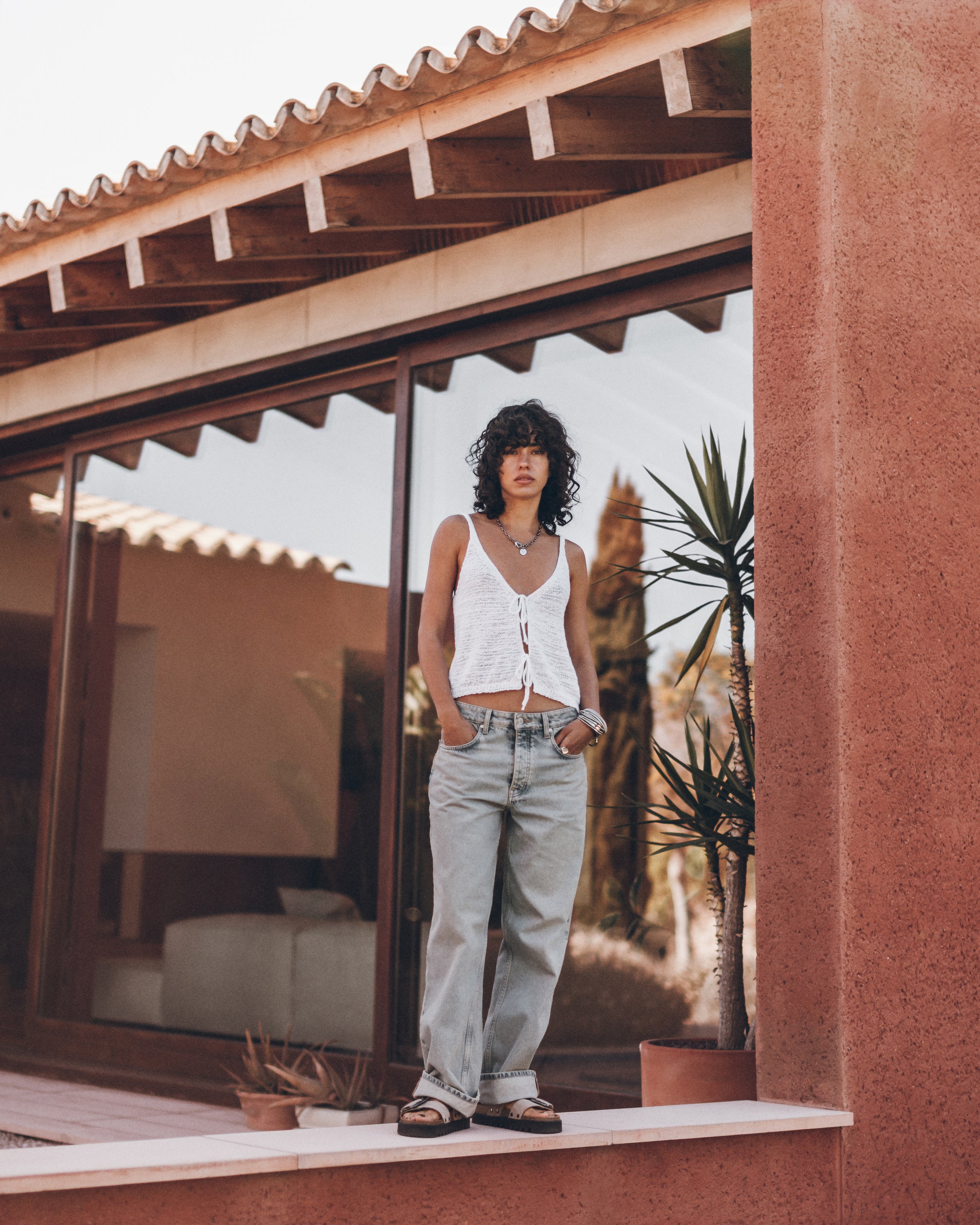 Woman standing in front of a modern house with a reflective surface