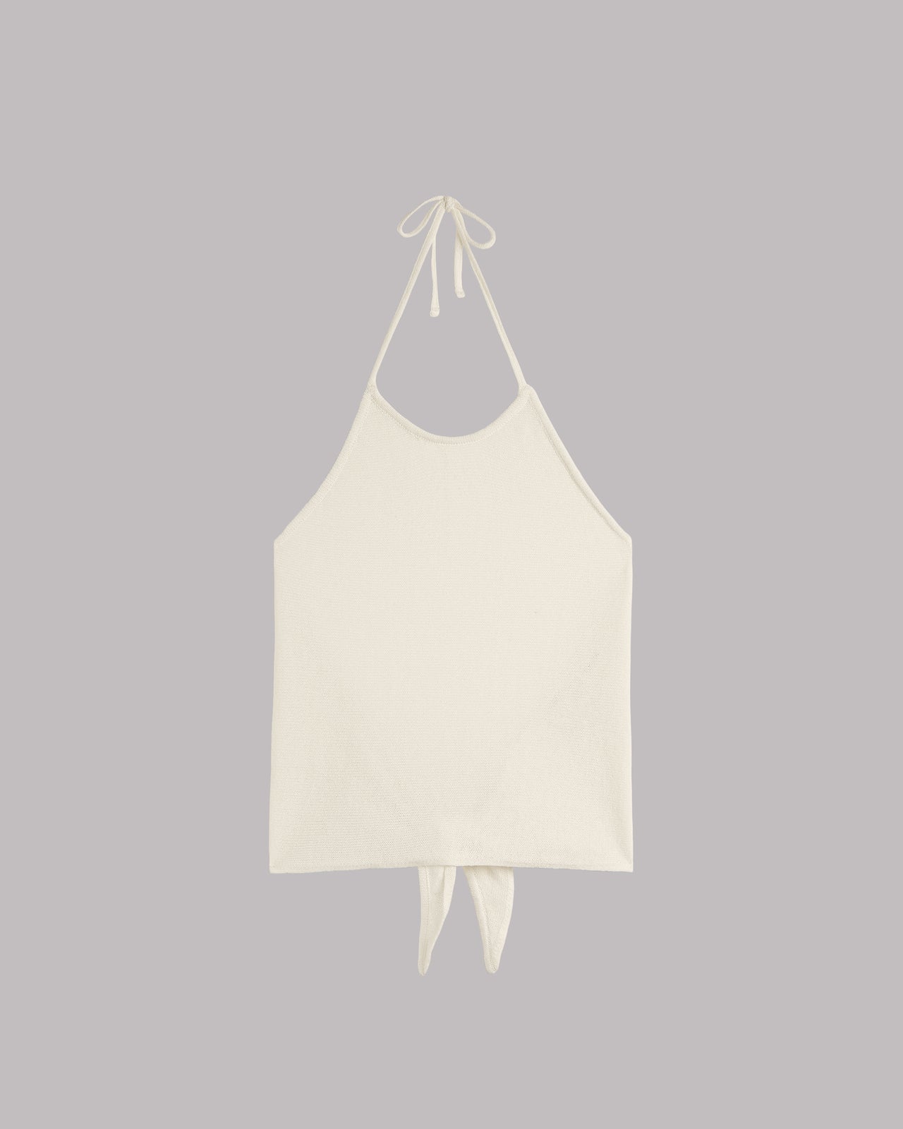 White halter top with back tie details on a gray background.