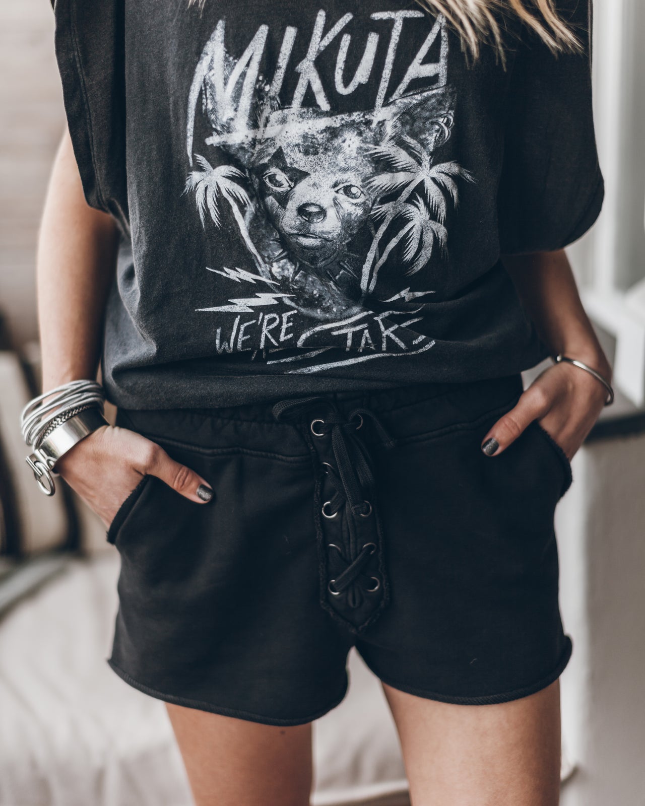 Black drawstring shorts with front pockets and soft fabric worn with graphic t-shirt.