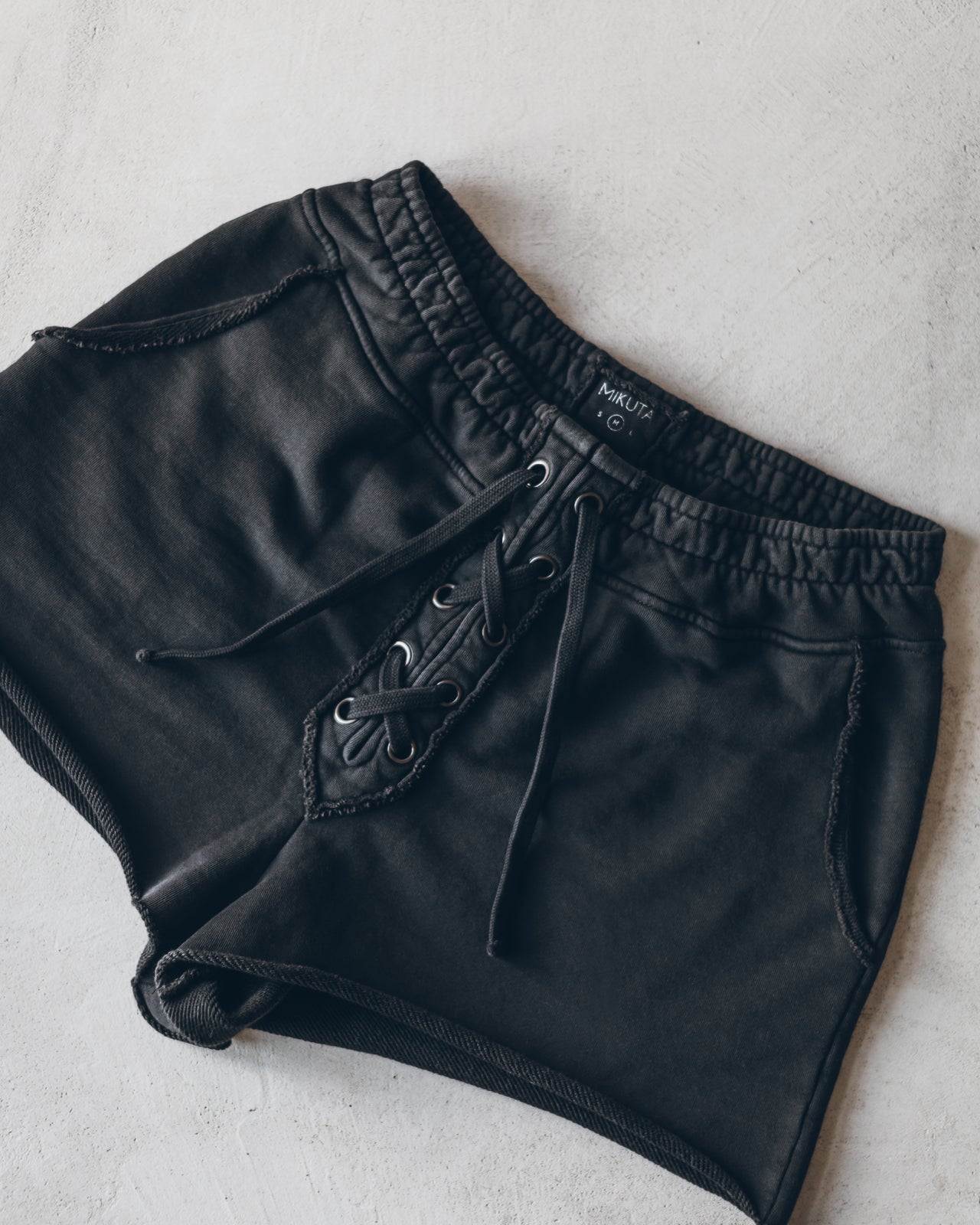 Charcoal-colored casual shorts with elastic waistband and front lace-up detail.