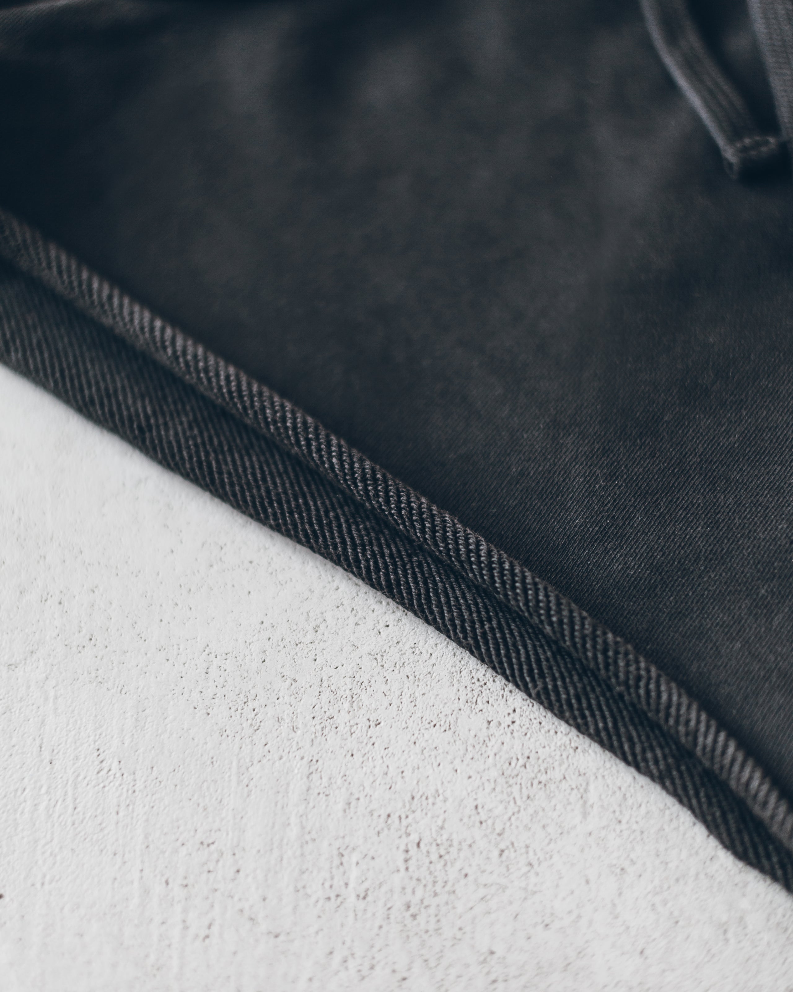 Close-up of charcoal-colored shorts hem with textured, durable fabric and reinforced stitching.