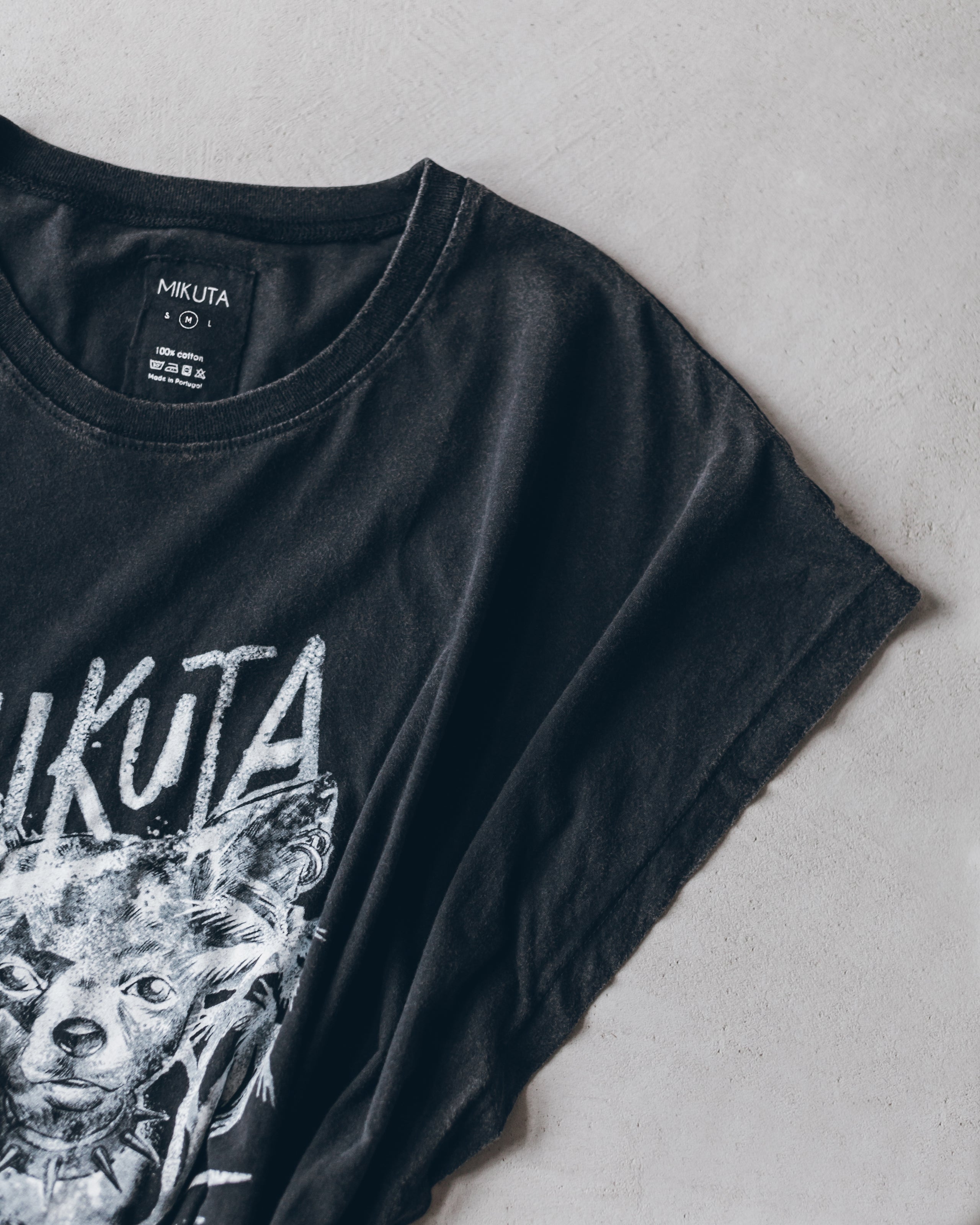 Black crew neck t-shirt with distressed white wolf graphic and "MUKUTA" text on front.
